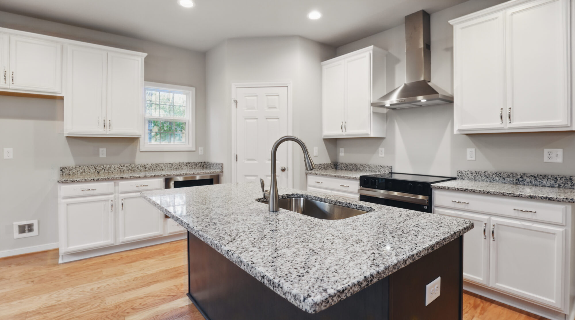 Modern Somerset Hill kitchen with white cabinets, granite countertops, stainless appliances, and central island sink.