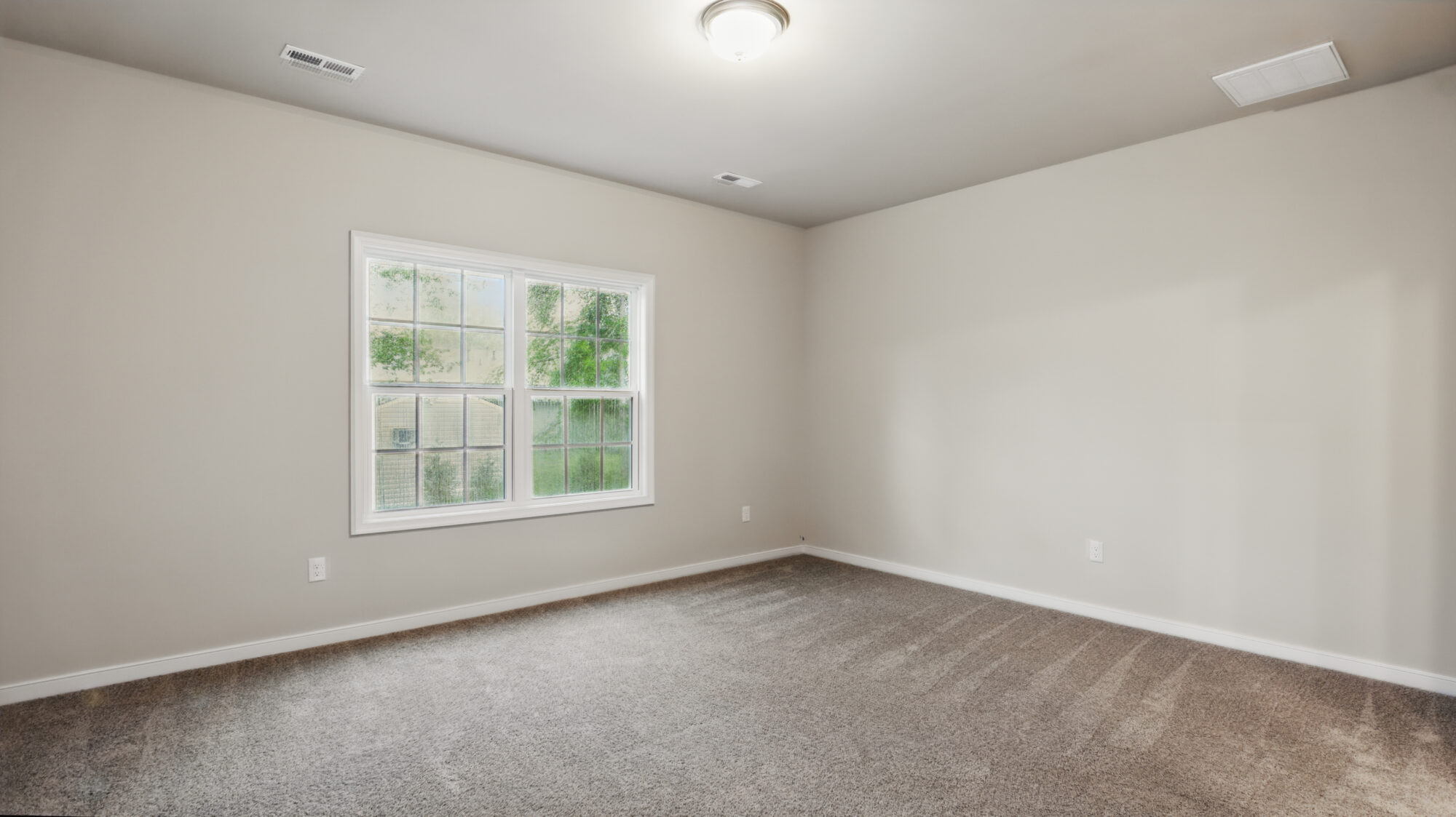 Empty room in Somerset Hill with beige walls, carpeted floor, window, and ceiling light fixture.