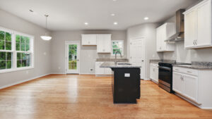 Spacious modern kitchen with white cabinets, granite countertops, island, and hardwood floors in Somerset Hill.