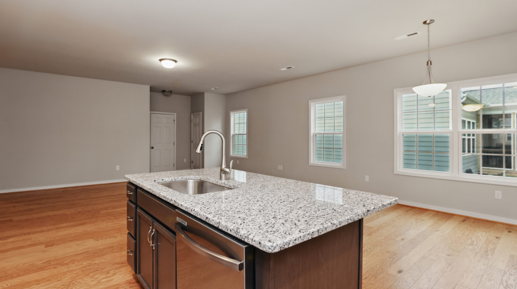 Modern Somerset Hill kitchen with granite island, stainless steel sink, hardwood floors, and large Bethany windows.