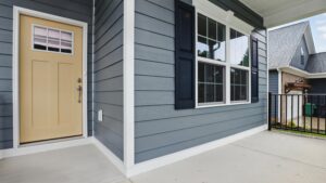 Front porch of a Somerset Hill house with blue siding, beige door, black shutters, and large windows.