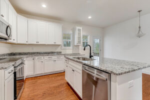 Modern Somerset Hill kitchen with white cabinets, granite countertops, and stainless steel appliances.
