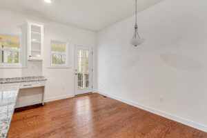 Bright Somerset Hill kitchen with hardwood floors, granite countertops, and a glass door leading outside.