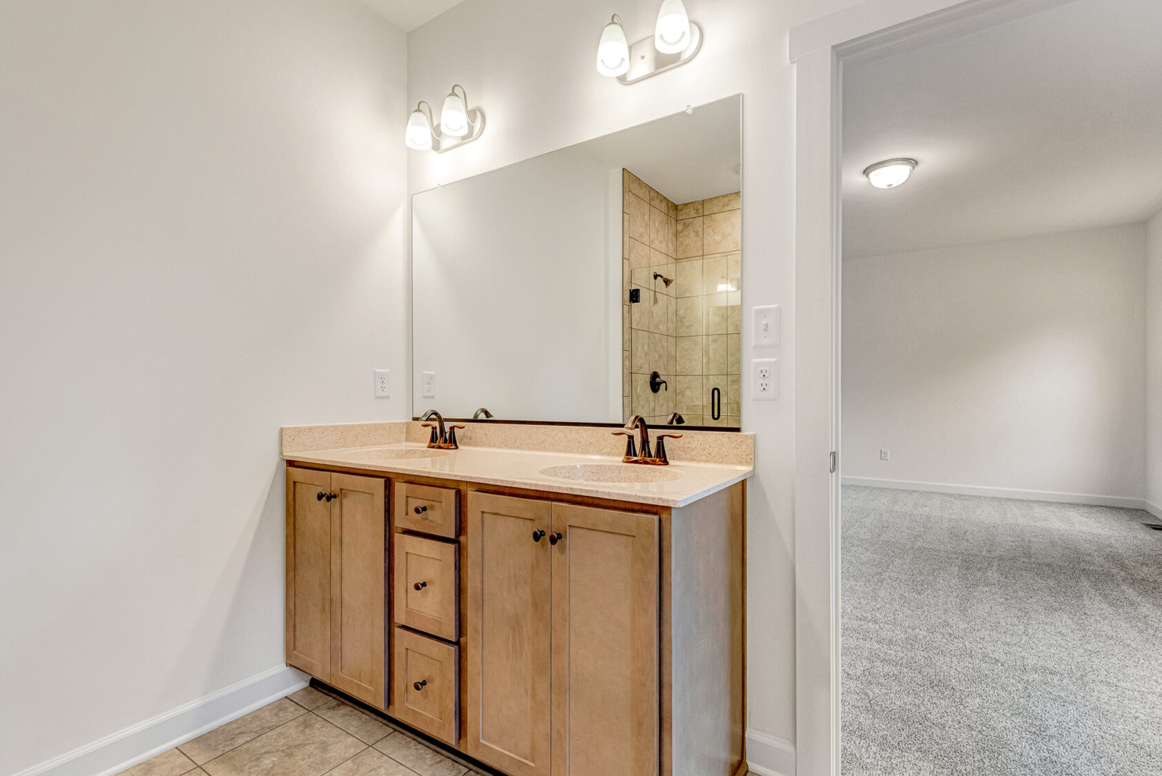 Bathroom at Somerset Hill with wood vanity, double sink, and large mirror—Kate's serene retreat with a tiled shower view.