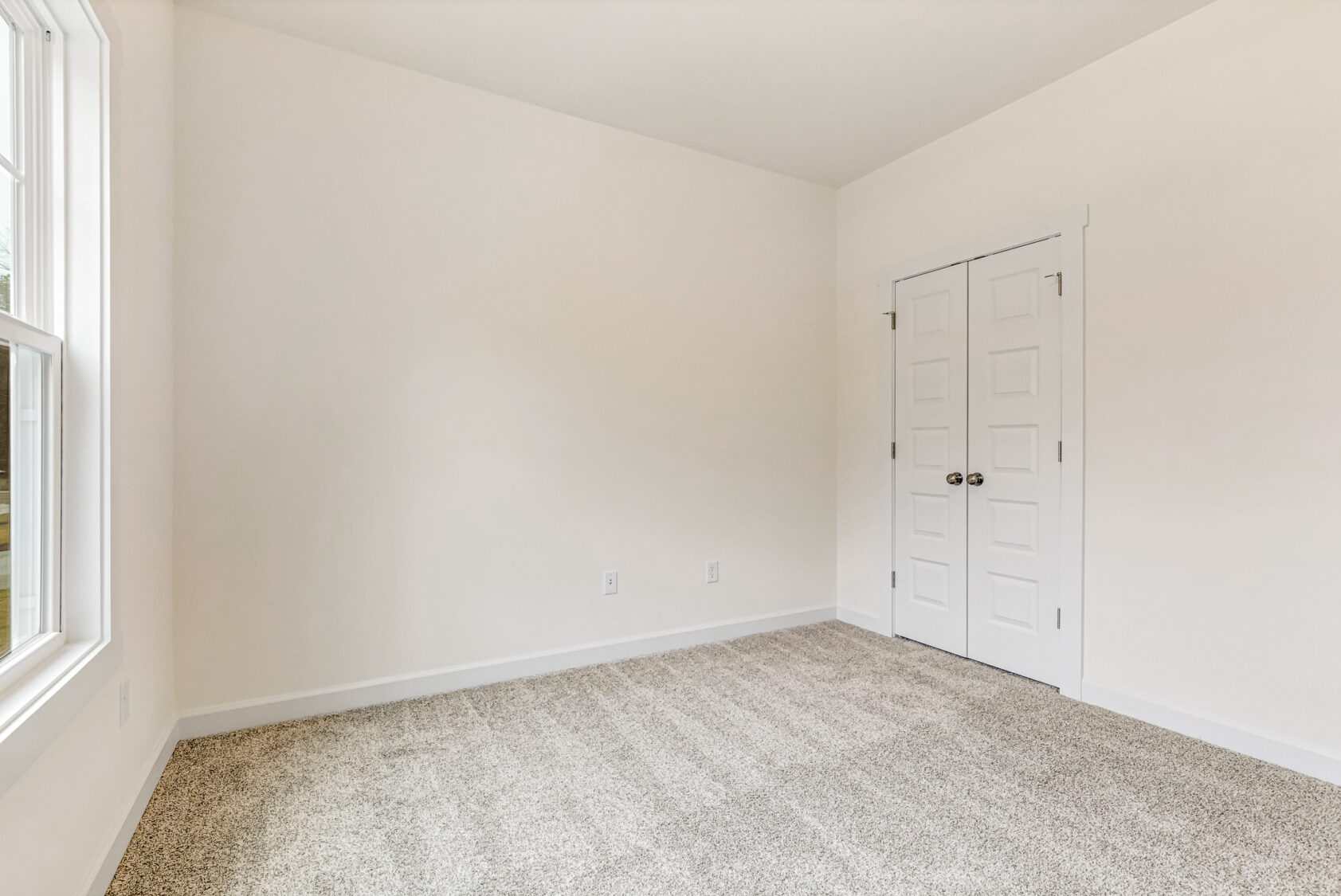 Empty room in Somerset Hill with beige carpet, white walls, a window left, and double closet doors right—listed by Kate.