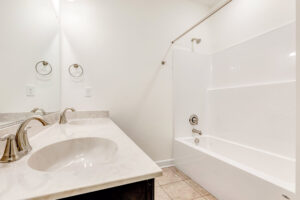 White bathroom with double sinks, marble countertop, and tub in the heart of Somerset Hill.