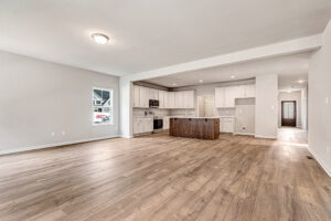 Spacious open-concept kitchen and living area with wood floors, white cabinets, and island in Somerset Hill's Lot 8.