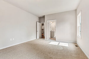 Somerset Hill's Lot 8 offers an empty beige carpeted room with white walls, two doors, and a bright window.