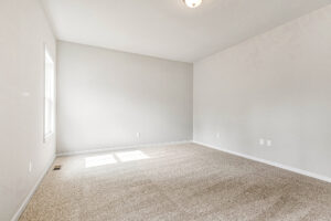 Empty room in Somerset Hill with beige carpet, light gray walls, and sunlight streaming in—welcome to Lot 8.