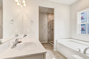 Bright bathroom in Somerset Hill's Lot 8 features double sinks, glass shower, soaking tub, and ample natural light.