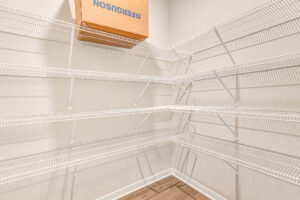Somerset Hill Lot 8: Empty white wire shelving in a corner pantry, with one cardboard box on the top shelf.