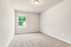Empty, carpeted room with beige walls in Somerset Hill, Lot 8; single window with natural light and ceiling light.