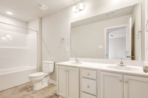 Bright Somerset Hill bathroom with double sinks, large mirror, and neutral palette—featured in Lot 8.
