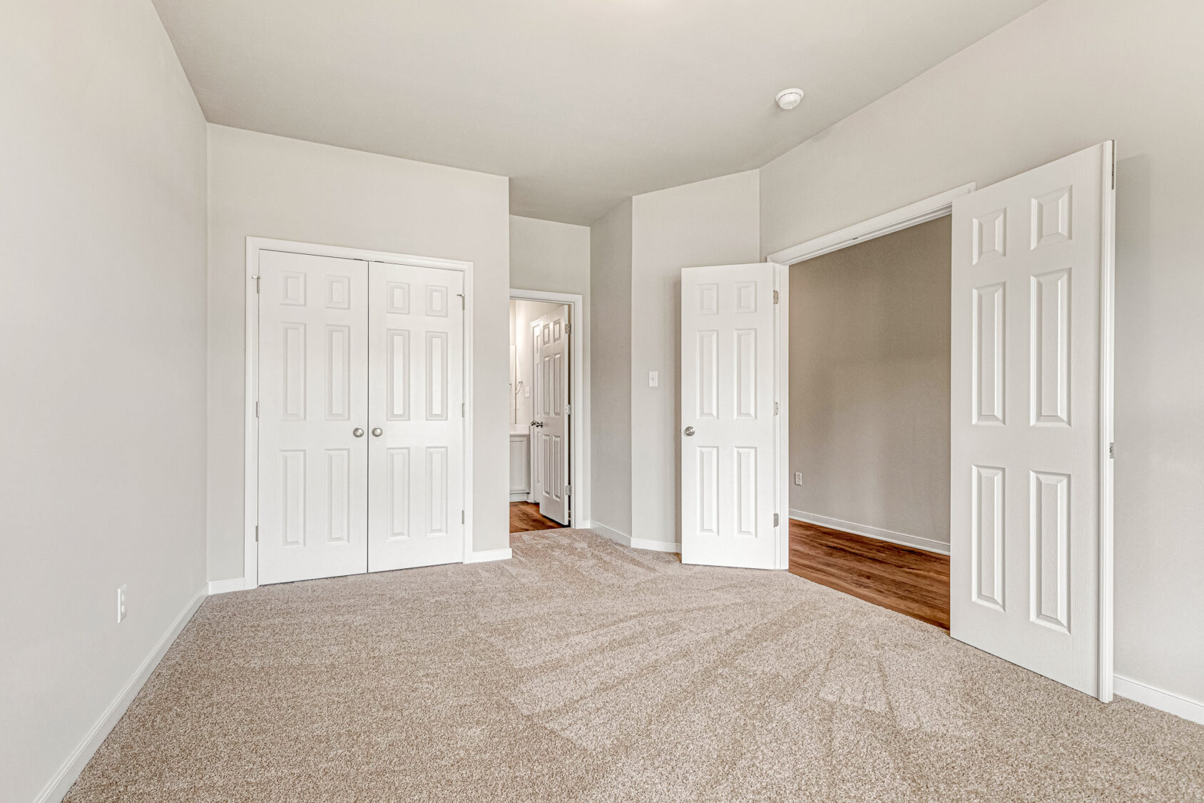 Spacious, carpeted Somerset Hill room with two closets, white doors, and open entry to hallway on Lot 8.