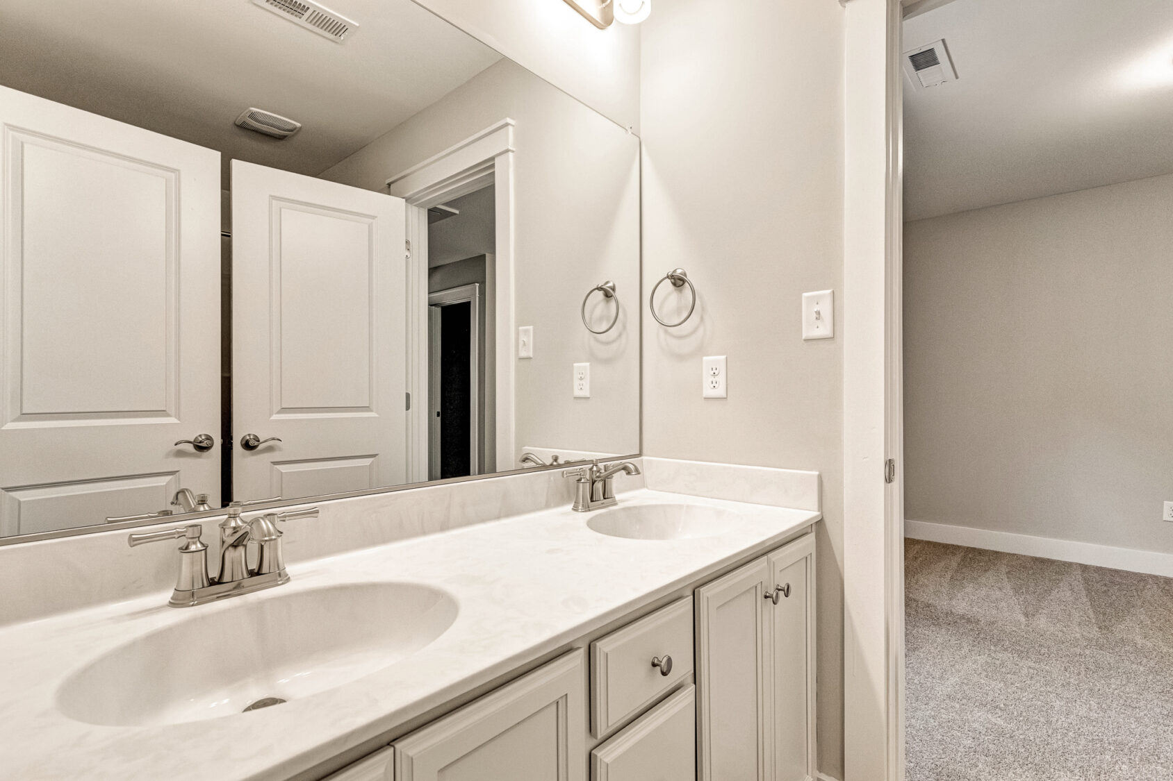 Somerset Hill Lot 7: Double sink vanity, white countertop, mirror, open doors, towel rings, and bright lighting.
