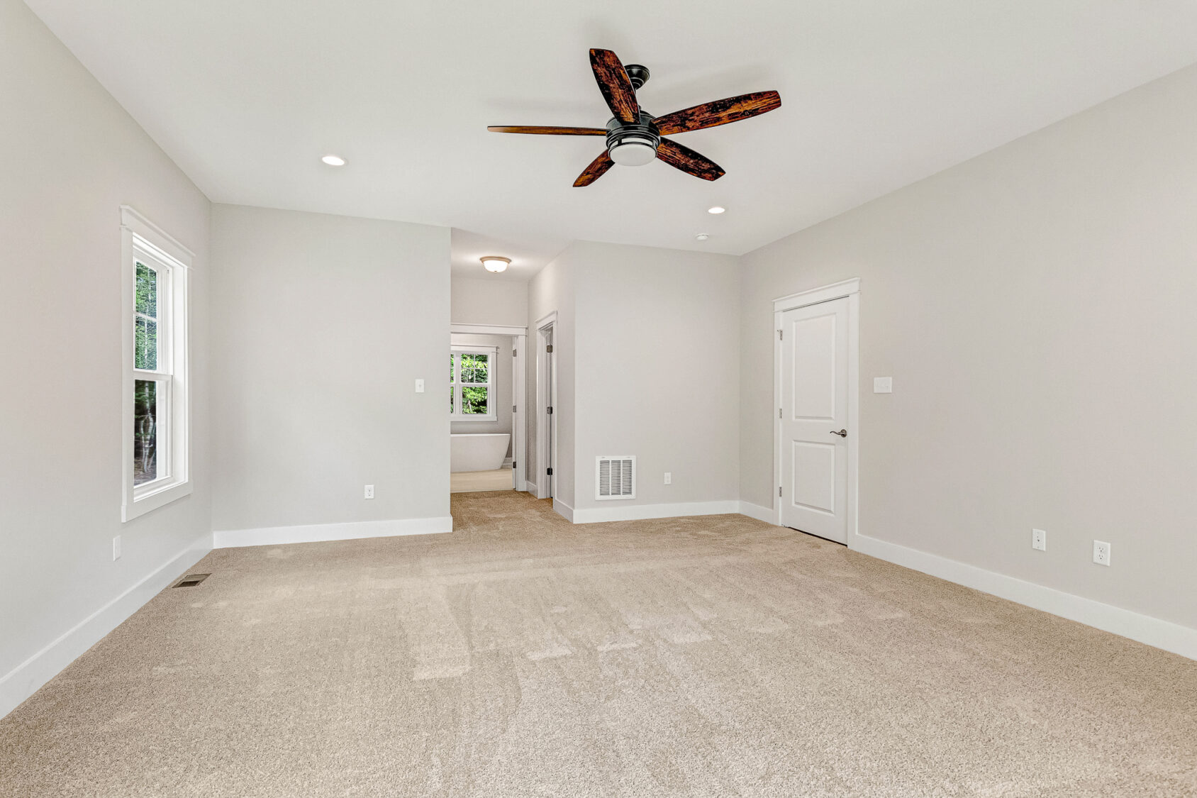 Spacious, empty bedroom in Lot 7, Somerset Hill, featuring beige carpet, white walls, and a ceiling fan.