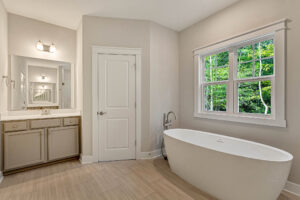 Modern bathroom in Somerset Hill Lot 7 with a freestanding tub, large window, and double sink vanity in neutral tones.