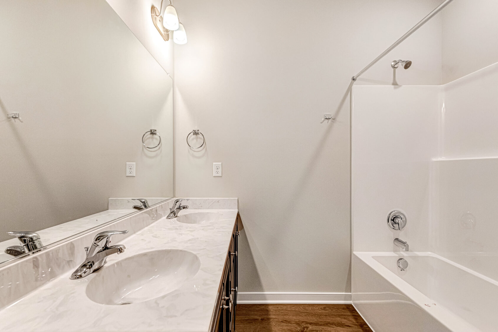 Modern Somerset Hill bathroom with double sink vanity, marble countertop, mirror, tub, and white walls.
