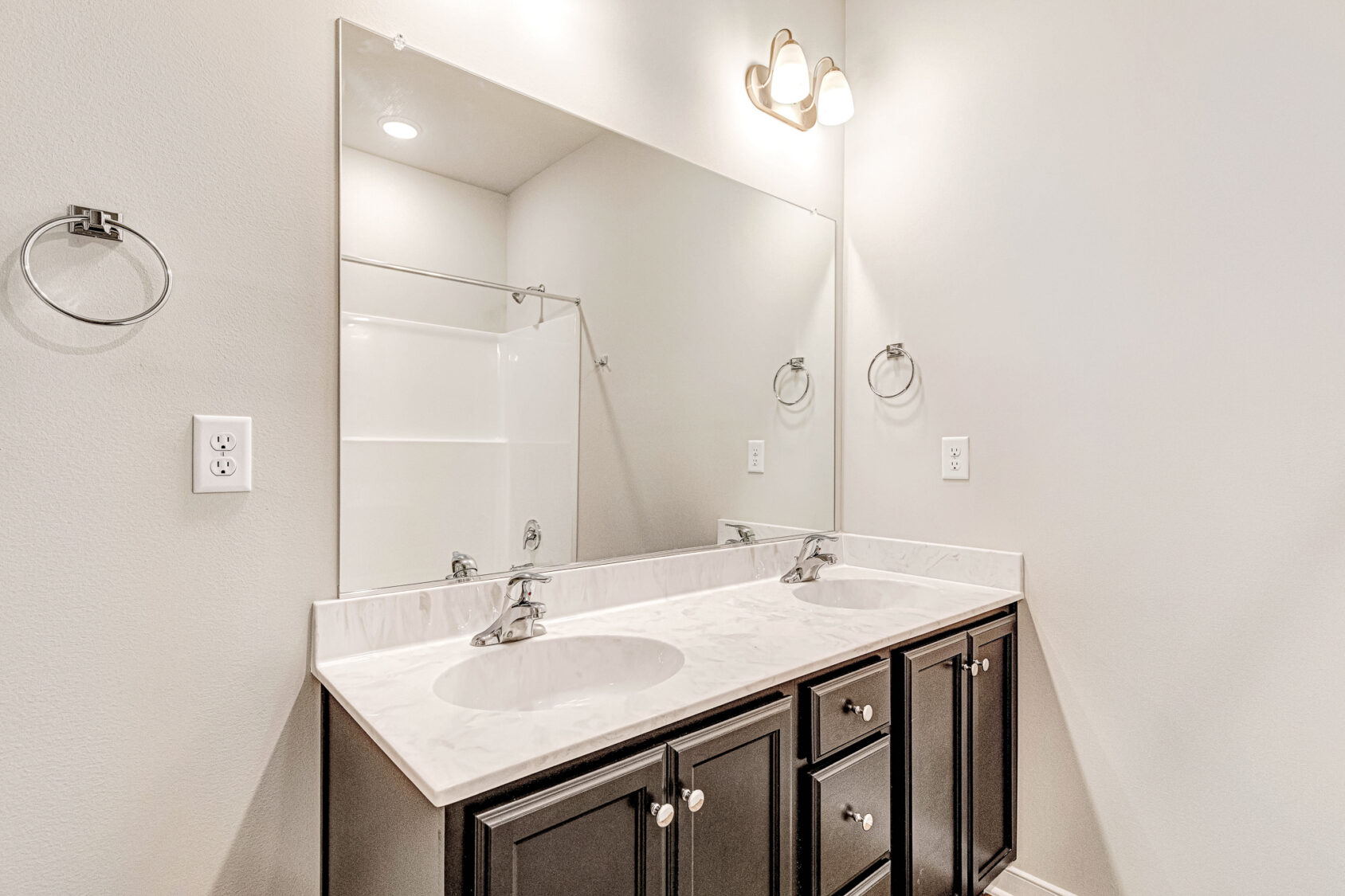 Somerset Hill Lot 4: Double-sink vanity with dark cabinets, large mirror, and bright overhead lighting.