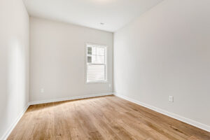 Empty room in Somerset Hill's Lot 4, with light wood flooring, white walls, and a single sunlit window.