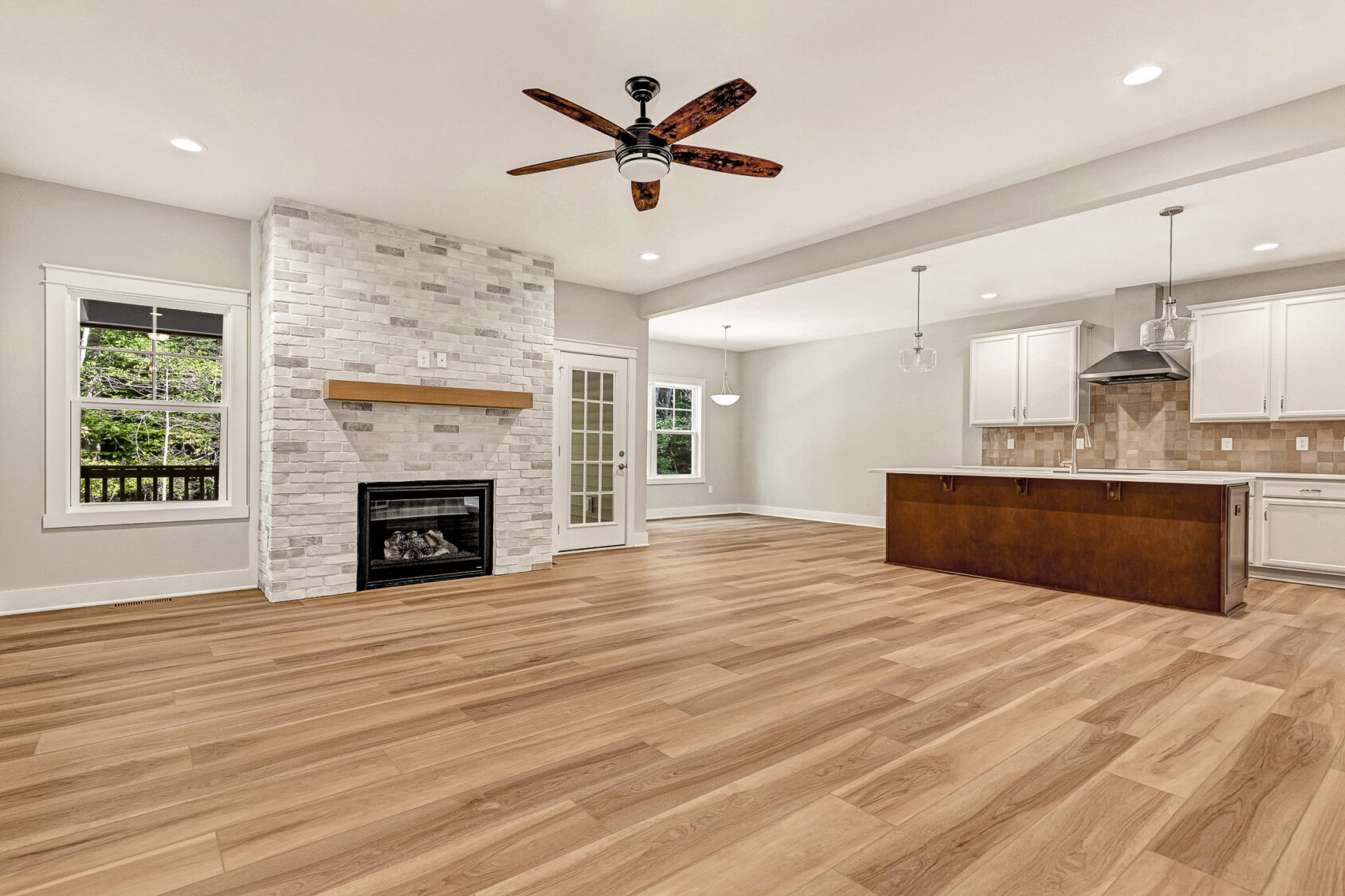 Open living area with wood floors, fireplace, and kitchen island in Somerset Hill’s Lot 7.