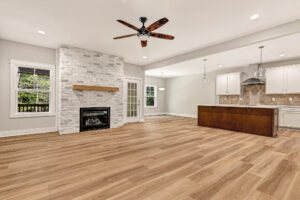 Open living area with wood floors, fireplace, and kitchen island in Somerset Hill’s Lot 7.