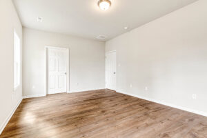 Empty room in Somerset Hill, Lot 4 features wood flooring, white walls, two doors, a window, and a ceiling light.