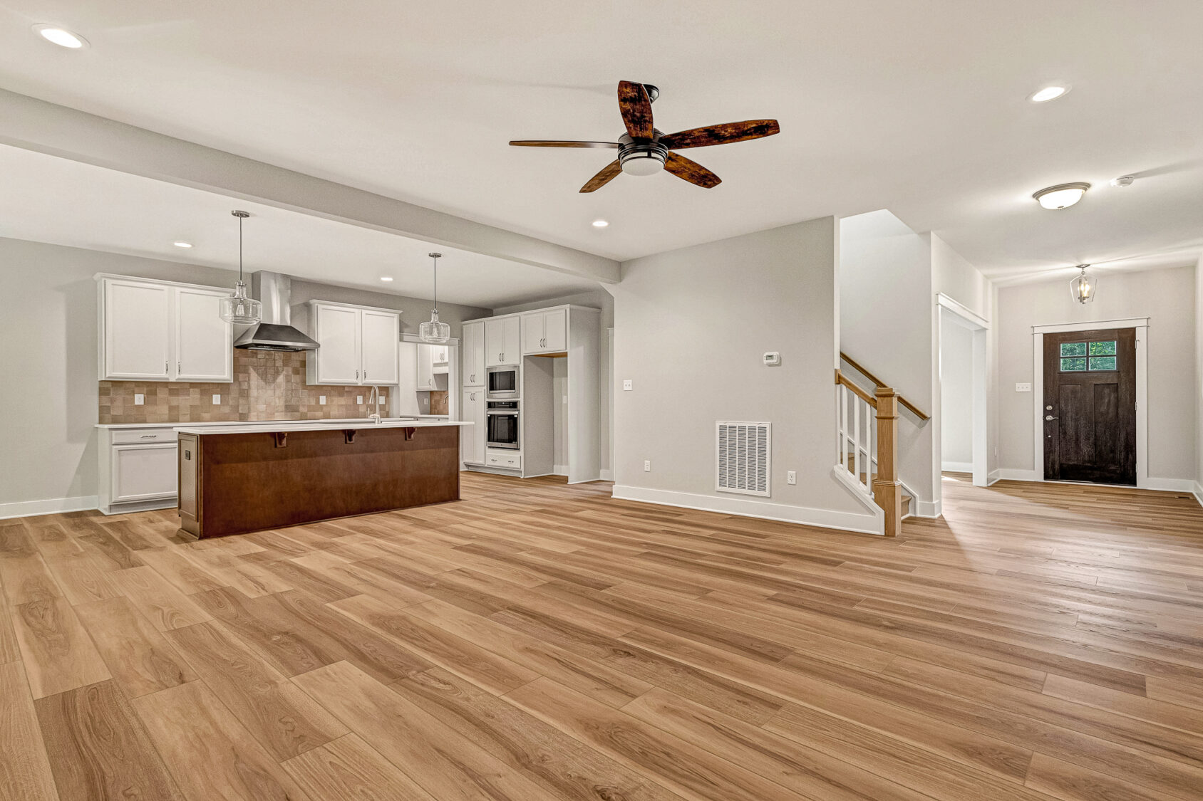 Spacious open-plan kitchen and living area in Somerset Hill’s Lot 7, featuring wood floors and modern lighting.