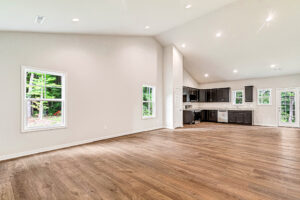 Spacious open-concept room in Somerset Hill, featuring wood floors, white walls, and a modern kitchen with dark cabinets.