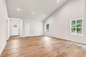 Empty room in Somerset Hill, Lot 4 with wood floors, vaulted ceiling, recessed lights, and scenic windows.