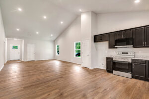 Spacious open-concept kitchen and living area in Lot 4, Somerset Hill, with wood floors and modern dark cabinets.