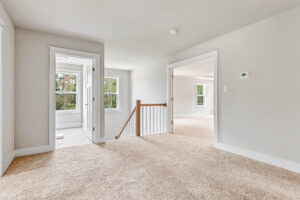 Bright, carpeted upstairs hallway in Lot 20, Somerset Hill, with white walls and open doorway leading to another room.