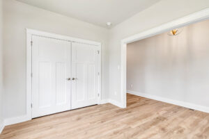 Empty room in Somerset Hill, Lot 20 with light wood flooring, white double doors, and light gray walls with white trim.