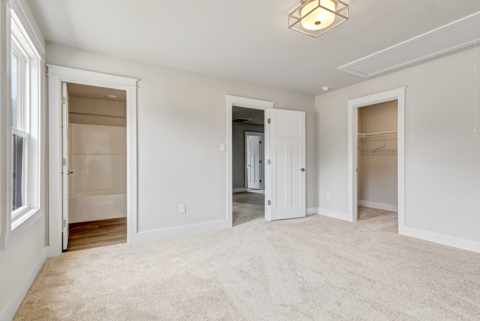 Bright, empty Somerset Hill bedroom with beige carpet, white walls, open closet, and access to Lot 20’s other rooms.