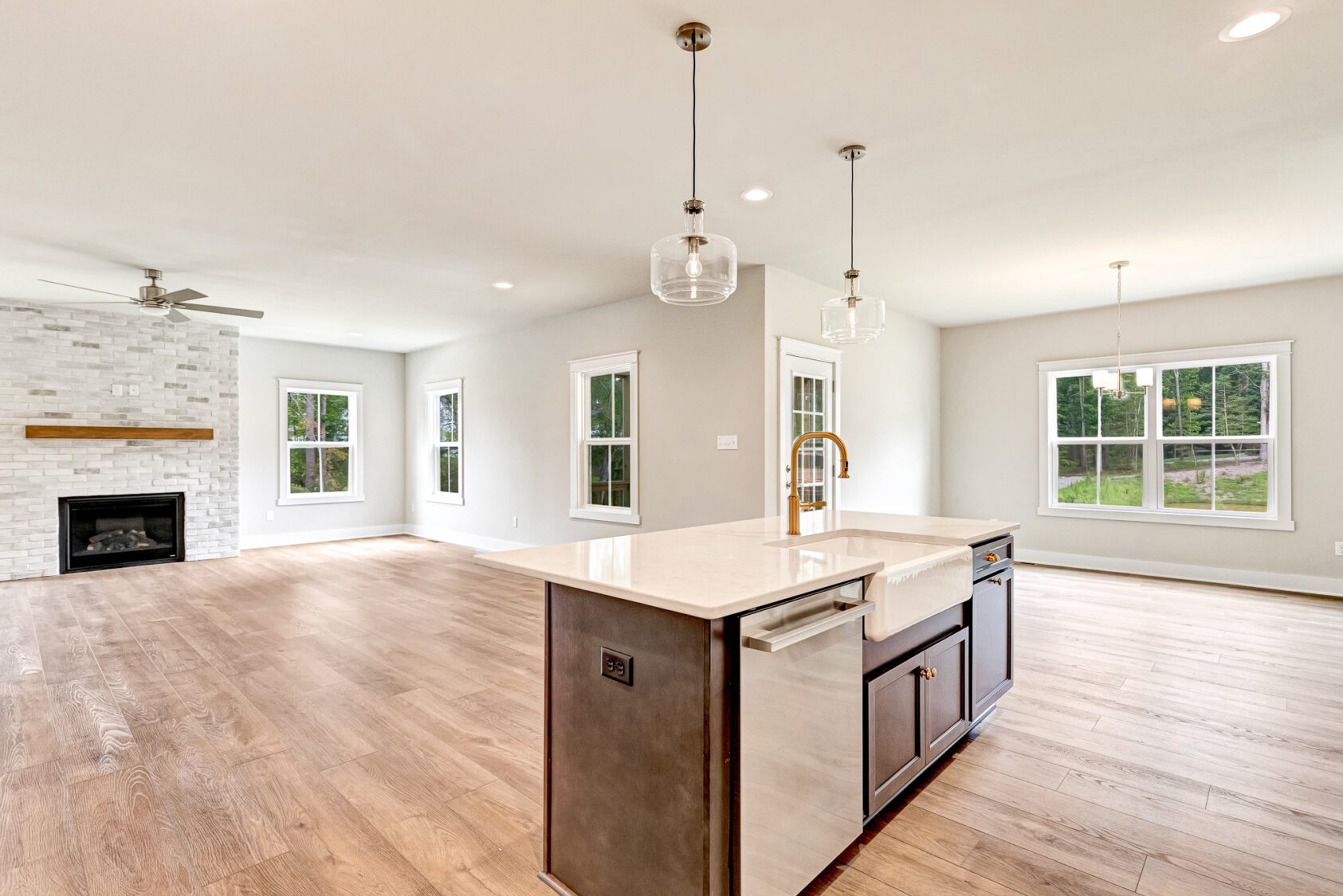 Bright open kitchen with island, wood floors, and large windows overlooking Somerset Hill on Lot 20.