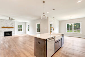 Bright open kitchen with island, wood floors, and large windows overlooking Somerset Hill on Lot 20.