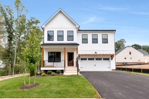 Modern white two-story house on Lot 20, Somerset Hill, with a porch, garage, driveway, and green lawn under a blue sky.